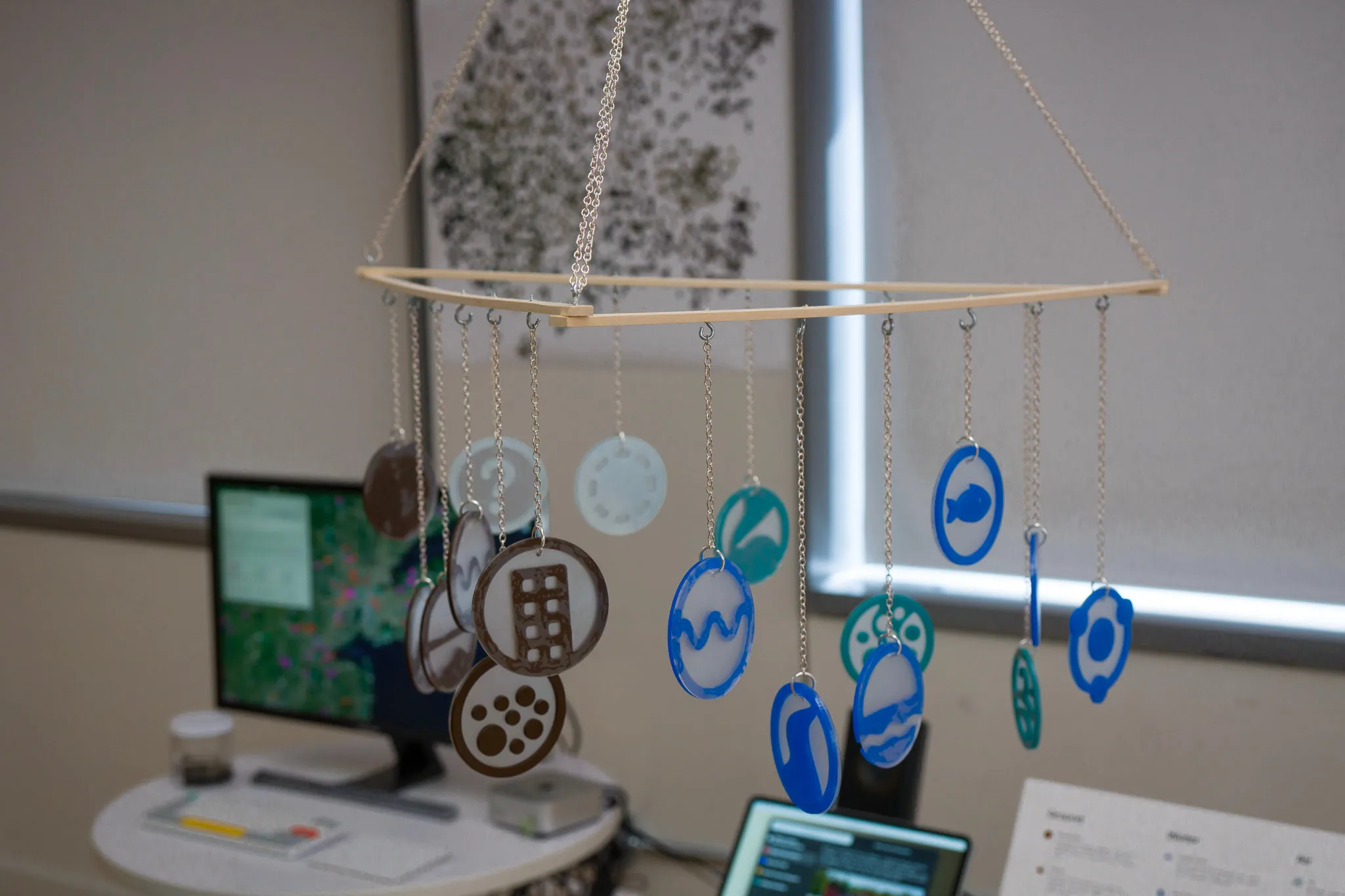 Mobile hanging down with laser-cut circular plastic icons of contamination types